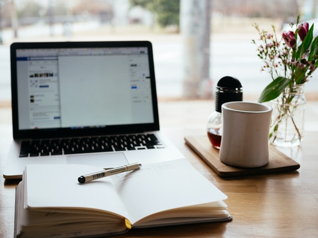 Laptop with book in front of it